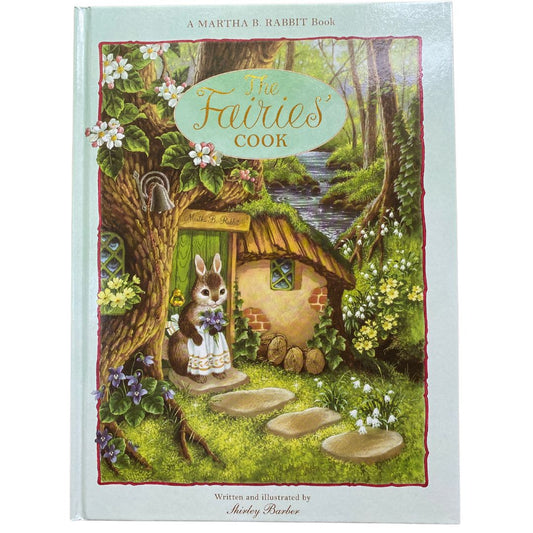 Cover of The Fairies cook by shirley barber shows martha b rabbit standing on the door step of a house that is in the foot of a tree. She is wearing an apron and holding a bunch of purple flowers