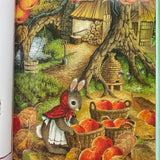 Martha b rabbit is outside collecting baskets of apples. The leaves are fall colours. You can see a beehive and a wood store in the background 